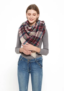 Detail shot of a thick plaid scarf with tassels, featuring red, green, and blue patterns