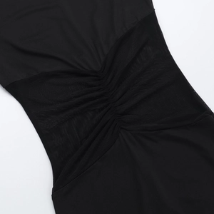 Detail of waist ruffles and symmetrical sheer mesh panels on a black jumpsuit