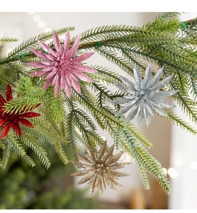 Glittery artificial Christmas flowers in pink gold and silver on pine tree branches