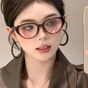 Boucles d'oreilles créoles léopard rétro portées par un mannequin en veste de cuir marron