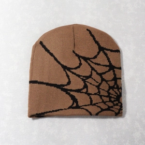 Detailed knit texture and black spider web jacquard pattern on a brown beanie hat