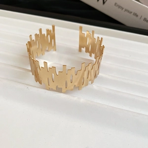 Detailed close-up of matte gold irregular hollow wide open cuff bracelet with vertical texture