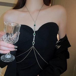Détail de la chaîne de corps argentée avec glands vert émeraude sur robe de soirée