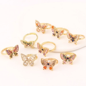 Elegant gold butterfly ring set with multicolored cubic zirconia crystals on warm white background