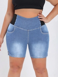 Detail of plus size denim shorts featuring elastic side waist bands and hem slits