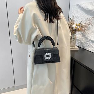 Elegant black crocodile-textured handbag with a sparkling diamond buckle and ruched handle