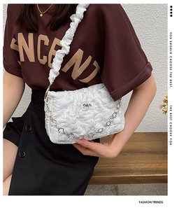 Close-up of white ruched shoulder bag with metallic floral chain and JINGPIN label