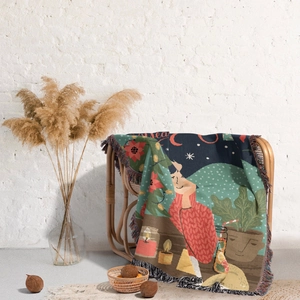Close-up of bohemian Christmas tree woven blanket with fringe details and festive patterns