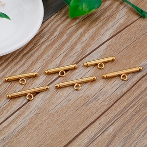Golden stainless steel OT toggle clasps for jewelry making on a wooden background