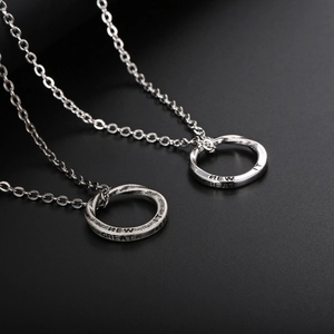 Vintage Mobius ring necklaces in silver titanium steel for couples on dark background