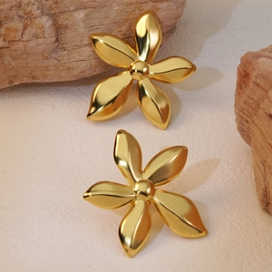 Elegant gold flower stud earrings in polished stainless steel displayed on a natural stone surface