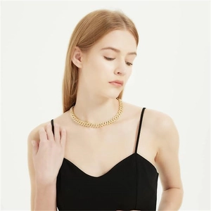 Close-up of a high-shine golden cuban link necklace on model with punk style