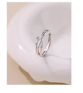 Close-up of silver crisscross ring with zircon stars and adjustable open band design