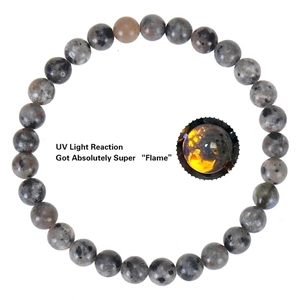 Detail showing natural flame stone bead bracelet with vibrant UV light reaction effect