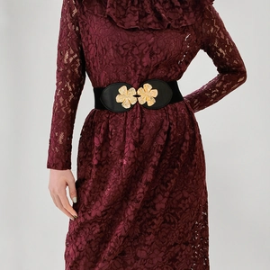 Detailed view of elastic waist belt featuring two golden floral metal buckles on a red dress