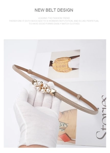 Detailed view of women's khaki leather belt featuring gold buckle with pearls and crystals