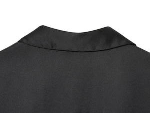 Vista dettagliata della trama del tessuto in raso nero sul colletto posteriore della camicia