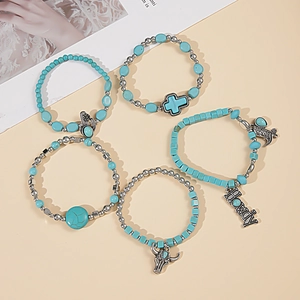 Detail of 5-piece Bohemian turquoise bracelet set with cross, bull head, and cactus charms