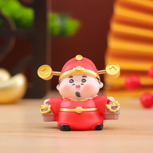 Close-up of a cute God of Wealth figurine with gold coins and a basket of gold ingots
