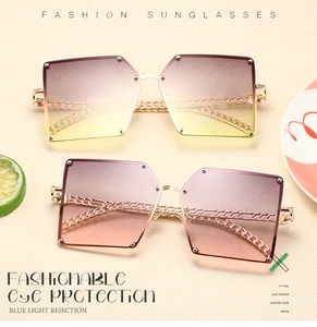 Detail of square oversized sunglasses with gold chain temples and gradient lenses