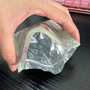 Close-up of resealable teddy bear bag showing the inner aluminum foil layer and seal