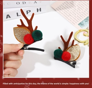 Détail de pinces à cheveux bois de renne de Noël avec pompons en peluche et feuilles dorées