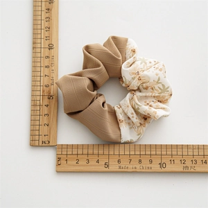 Floral and khaki patchwork scrunchie hair tie measuring 10cm on a white background