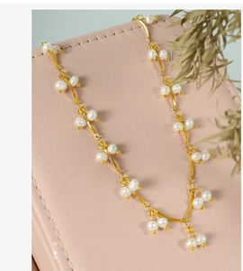 Close-up of elegant small freshwater pearl clusters on a delicate golden chain necklace