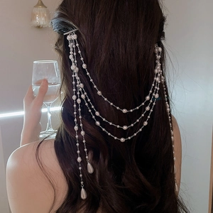 Detail of long pearl tassel hair clip with cascading metal chains and water-drop pendants