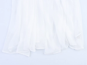 Close-up of white chiffon fabric texture and vertical pleats on a loose camisole dress