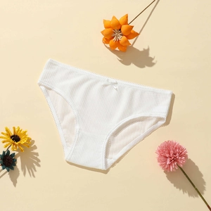 Close-up of white ribbed low-waist panties with delicate lace edges and a small bow detail