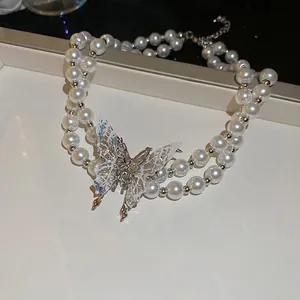 Double-layered pearl necklace with a large iridescent butterfly pendant and silver chain