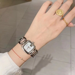 Detail of silver square quartz watch with a unique hollow chain link metal strap on wrist