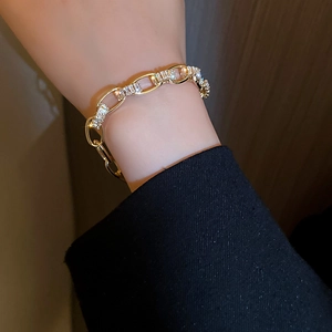 Details des eleganten goldfarbenen Kettenarmbands mit Zirkonia-Steinen am Handgelenk