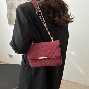 Classic burgundy suede shoulder bag with V-quilted texture and gold chain strap