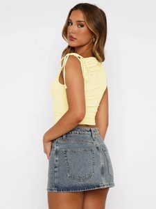 Fashionable yellow drawstring crop top with irregular straps and denim mini skirt