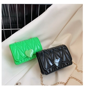 Detail of heart-shaped silicone crossbody bags with quilted texture and gold chains