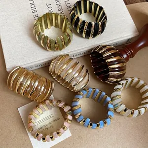 Colorful resin bead bracelets with gold metal spacers on an aesthetic lifestyle background