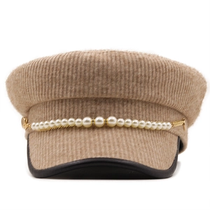 Detailed view of camel newsboy cap with pearl chain and black leather trimmed brim