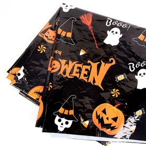 Detailed view of Halloween tablecloth featuring spooky ghosts and orange pumpkin motifs