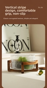 Detailed view of the vertical ribbed glass salad bowl featuring a solid wood cross base