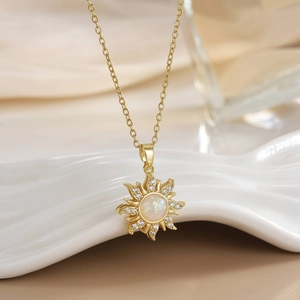 Macro shot of gold sun pendant with opal center and zircon accents on satin