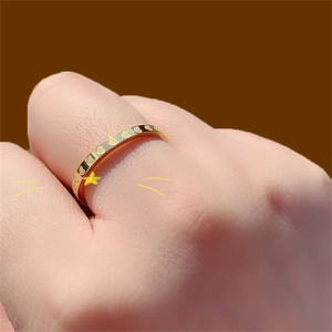 Minimalist gold titanium steel ring with heart patterns shown on finger
