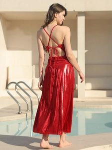 Détail de robe longue rouge métallisée avec bretelles croisées au dos et découpe à la taille