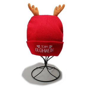 Detail of red Christmas knit hat with elk antlers and Team Glühwein white embroidery