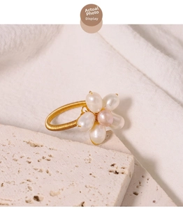 Detailed macro shot of flower pearl ring with golden wire band and pink pearl center
