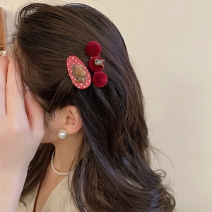 Detail of red velvet dog and bear hair clips set featuring 3D motifs on a female model