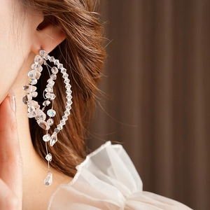 Detailed side view of iridescent beaded tassel earrings with intricate wire wrapping