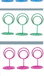 Vertical row of blue, green, and rose red spiral base metal memo holders on white background