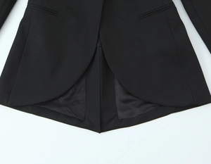 Détail de l'ourlet arrondi du blazer noir avec tissu tissé et doublure en satin chic